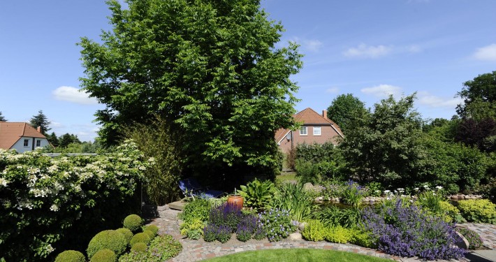 atriumgaerten-kleine-gaerten-innenhof-atrium-oder-patio (21) Immergrüne Kugeln und blühende Stauden werden von einer Natursteinpflasterung eingefasst